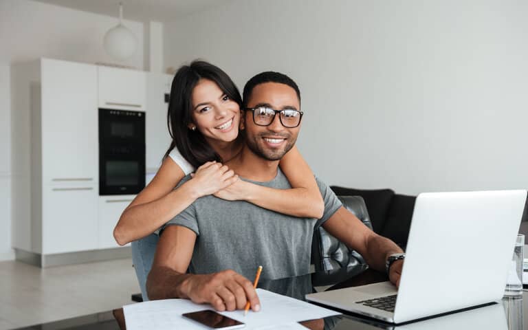 Young Loving Couple Using Laptop And Analyzing Their Finances Looking At The Camera Sbi 302895361 Edited